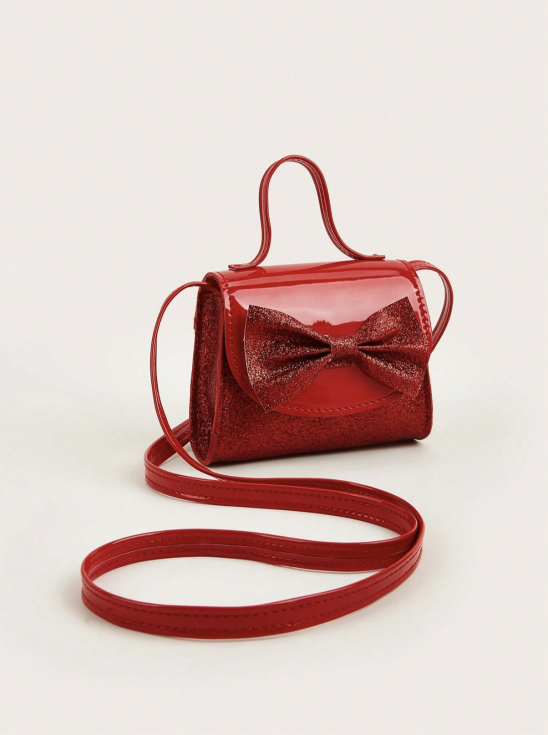 Röd glitterväska för flickor med lång axelrem och stor rosett framifrån